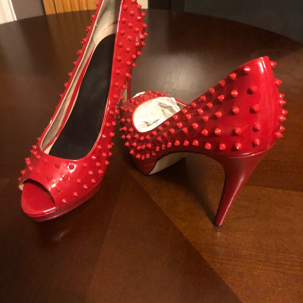 Red spiked open toe pumps